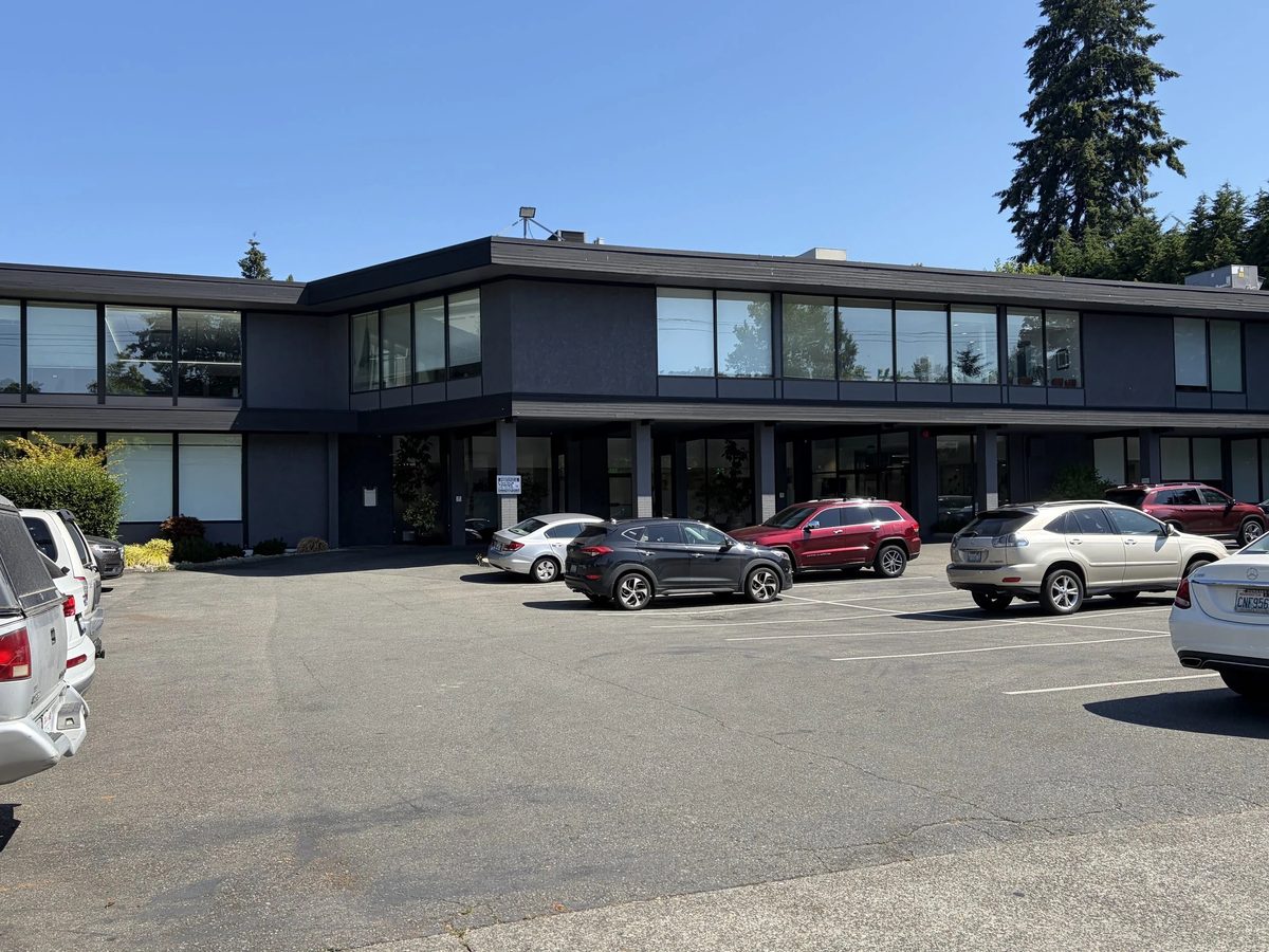 The two-story office building with its parking lot in front